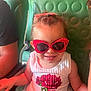 Tania a rejoint le concours — aidez-le/la à gagner de superbes lots ! toddler, child, sunglasses, red, dress, rose, smile, seat, green, cushion, happy, indoor, person, cute, fashion, glasses, young_child, casual, portrait, hair