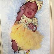 Loni joined the competition — help win amazing prizes! baby, blanket, child, cozy, cute, face, feet, hands, headband, indoors, infant, newborn, peaceful, portrait, resting, sleeping, smile, soft_texture, tutu, yellow_outfit