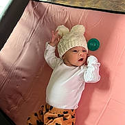 Autumn joined the competition — help win amazing prizes! baby, infant, hat, knit_hat, pom_poms, white_shirt, orange_pants, heart_pattern, pacifier, pink_surface, lying_down, cute, child, newborn, expression, soft, indoors, clothing, person, resting