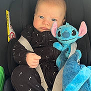 Sacha participe au concours pour gagner de l'argent avec cette photo : baby, infant, car_seat, stuffed_animal, plush_toy, blue, black_clothing, onesie, child, seat_belt, cute, face, expression, indoors, comfort, soft_toy, young, car_interior, portrait, sitting
