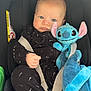 baby, infant, car_seat, stuffed_animal, plush_toy, blue, black_clothing, onesie, child, seat_belt, cute, face, expression, indoors, comfort, soft_toy, young, car_interior, portrait, sitting