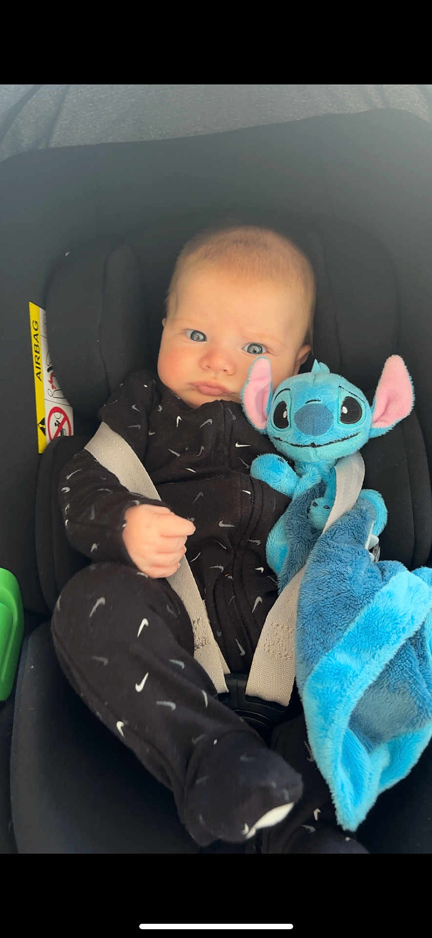 Sacha participe au concours pour gagner de l'argent avec cette photo : baby, infant, car_seat, stuffed_animal, plush_toy, blue, black_clothing, onesie, child, seat_belt, cute, face, expression, indoors, comfort, soft_toy, young, car_interior, portrait, sitting
