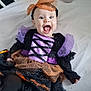 Darcey joined the competition — help win amazing prizes! baby, child, costume, halloween, crib, plush_toy, purple, orange, smiling, happy, person, infant, clothing, headband, bed, fun, cute, joyful, portrait, indoors