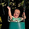 Jayden is registered to the contest to win money with this photo: toddler, child, swing, playground, smiling, happy, outdoor, sunlight, chains, seat, clothing, shorts, shirt, nature, daylight, joy, fun, person, portrait, play