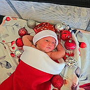 Kerrie joined the competition — help win amazing prizes! baby, newborn, christmas_stocking, red_hat, ornaments, red_ornaments, silver_ornaments, blanket, floral_pattern, holiday, festive, cute, infant, wrapped, cozy, lying_down, decorations, celebration, holiday_season, warm