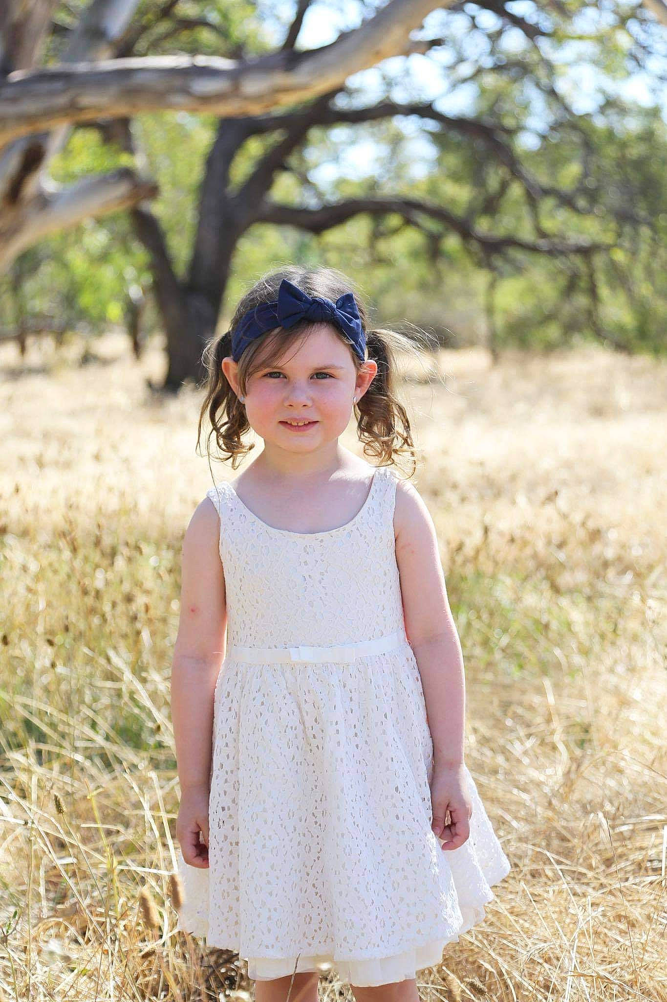 Billie is registered to the contest to win money with this photo: baby_toddler_clothing, beauty, brown_hair, child, clothing, day_dress, dress, fawn, grass_family, headwear, joy, mouth, nose, one_piece_garment, people_in_nature, person, shoulder, skin, spring, straw