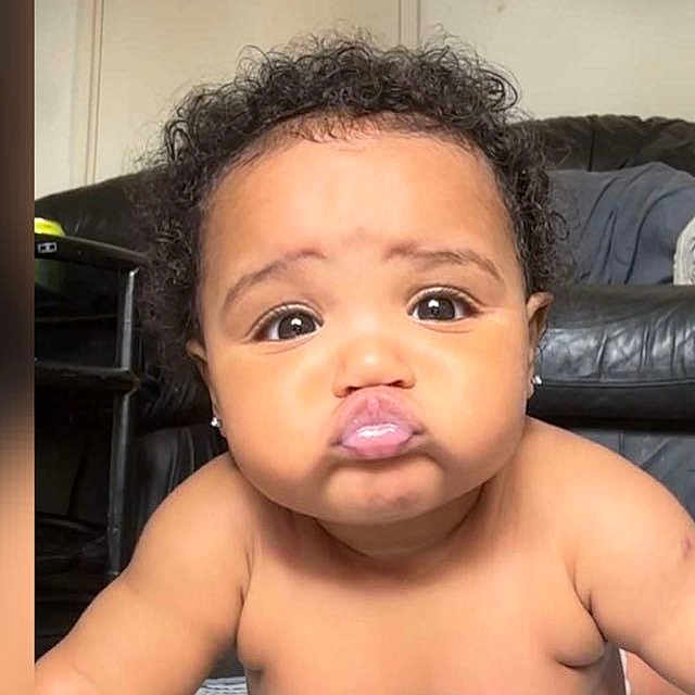 Zohra-Mai is registered to the contest to win money with this photo: adorable, baby, black_leather_couch, child, chubby_cheeks, closeup, curly_hair, cute, earrings, expression, eyes, face, indoor, infant, living_room, person, portrait, pout, skin, young