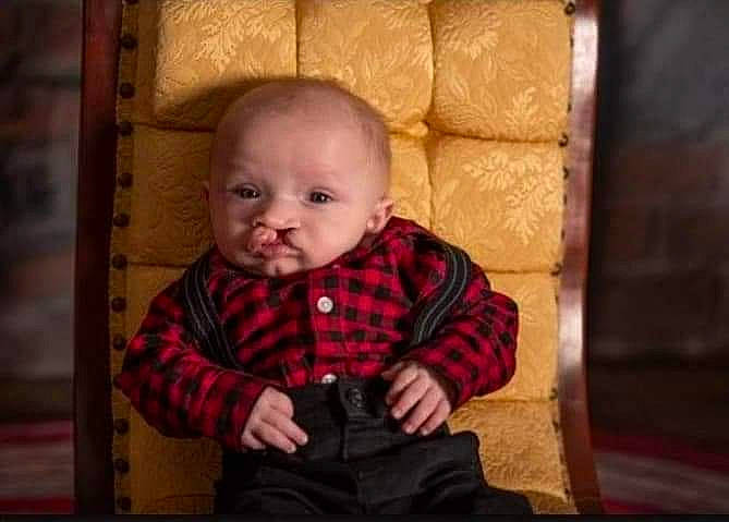 Braxton is registered to the contest to win money with this photo: baby, baby_toddler_clothing, cheek, clothing, comfort, eye, flash_photography, flooring, fun, happy, iris, nose, orange, person, plaid, skin, sleeve, smile, tartan, toddler