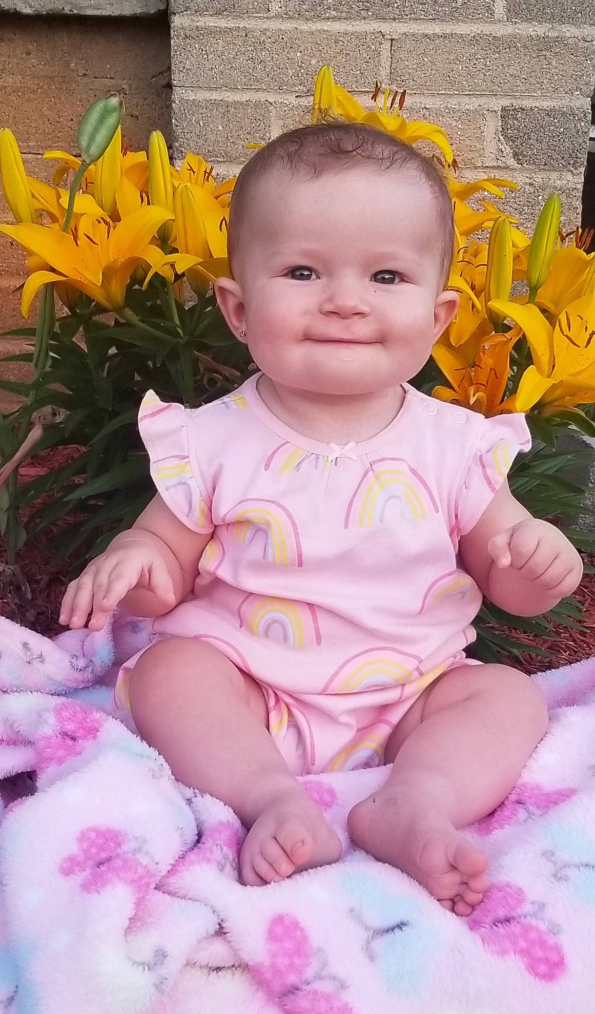 Kynslee is registered to the contest to win money with this photo: baby, baby_toddler_clothing, cheek, child, eye, face, flower, happy, head, iris, joy, person, petal, pink, plant, sitting, skin, smile, toddler, yellow