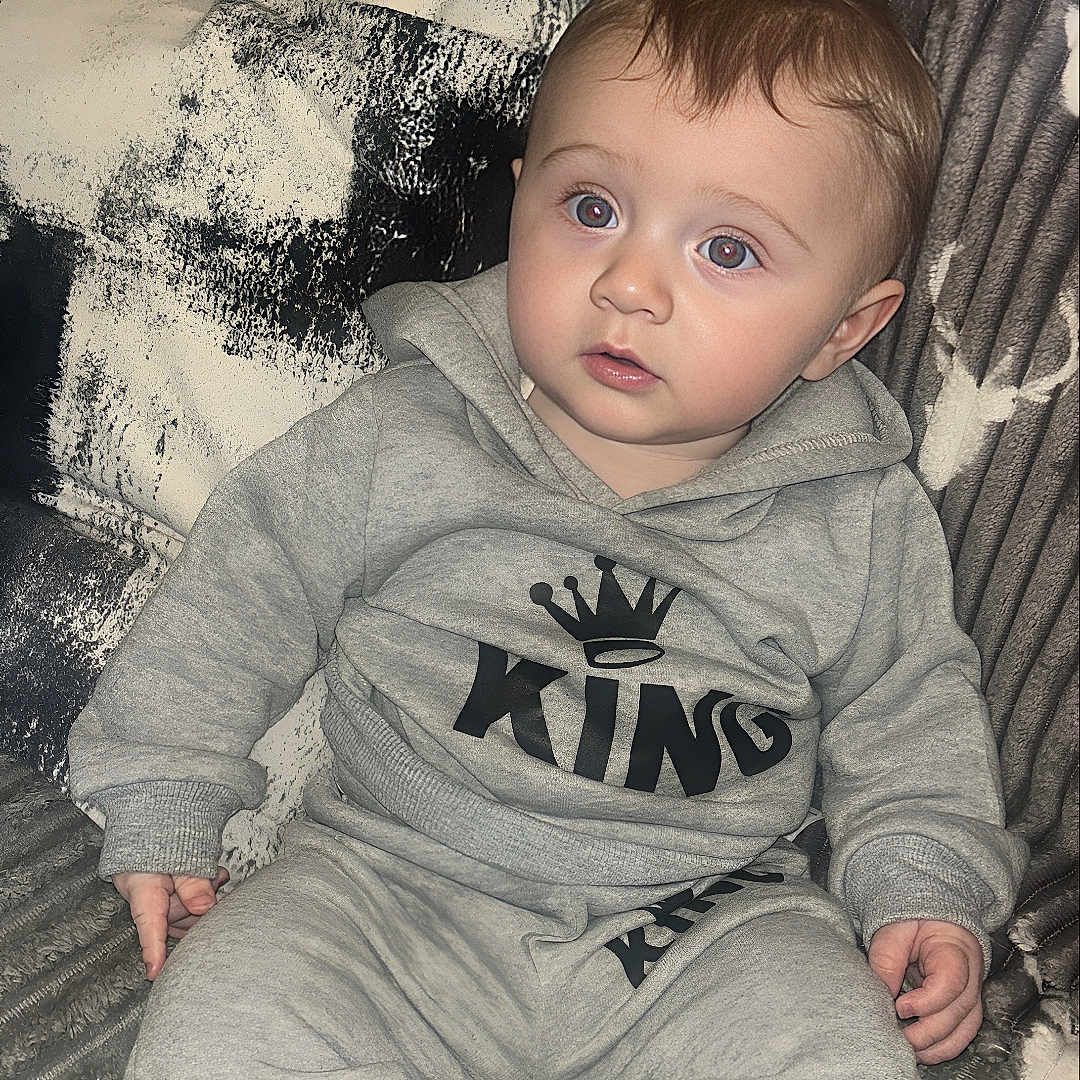 Tommy Junior joined the competition — help win amazing prizes! baby, bodypart, clothing, couch, face, finger, furniture, hand, head, homedecor, knitwear, longsleeve, pants, person, photography, portrait, sleeve, sweater, sweatshirt, t_shirt