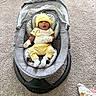 Christopher joined the competition — help win amazing prizes! baby, infant, yellow_hat, striped_pants, baby_rocker, carpet, blanket, white_mittens, indoor, child, cute, seated, expression, soft_lighting, floor, cozy, nursery, baby_clothing, baby_accessory, home