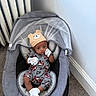 baby, infant, baby_rocker, hat, bear_hat, pajamas, white_socks, mesh_canopy, gray_fabric, carpet, radiator, corner, indoor, child, cute, looking_at_camera, seated, comfortable, home, cozy