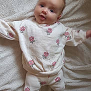 Olivia participe au concours pour gagner de l'argent avec cette photo : baby, blanket, child, cute, face, feet, floral_outfit, happy, head, indoors, infant, looking_at_camera, lying_down, pajamas, person, portrait, skin, smiling, soft_texture, young_child