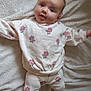 baby, blanket, child, cute, face, feet, floral_outfit, happy, head, indoors, infant, looking_at_camera, lying_down, pajamas, person, portrait, skin, smiling, soft_texture, young_child