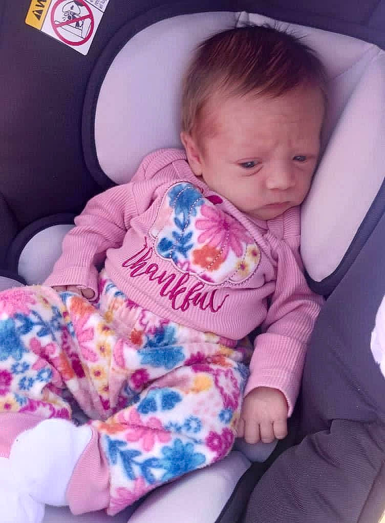 Blakelynn is registered to the contest to win money with this photo: baby, baby_in_car_seat, baby_toddler_clothing, car_seat, cheek, child, comfort, facial_expression, finger, head, human_body, lap, leg, person, pink, product, sitting, skin, sleeve, thigh