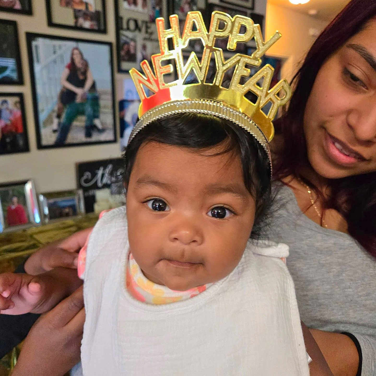 Mia Michelle is registered to the contest to win money with this photo: baby, celebration, child, closeup, clothing, crown, curious, face, family, happy, headwear, holding, indoor, new_year, person, photo_wall, portrait, smile, toddler, woman