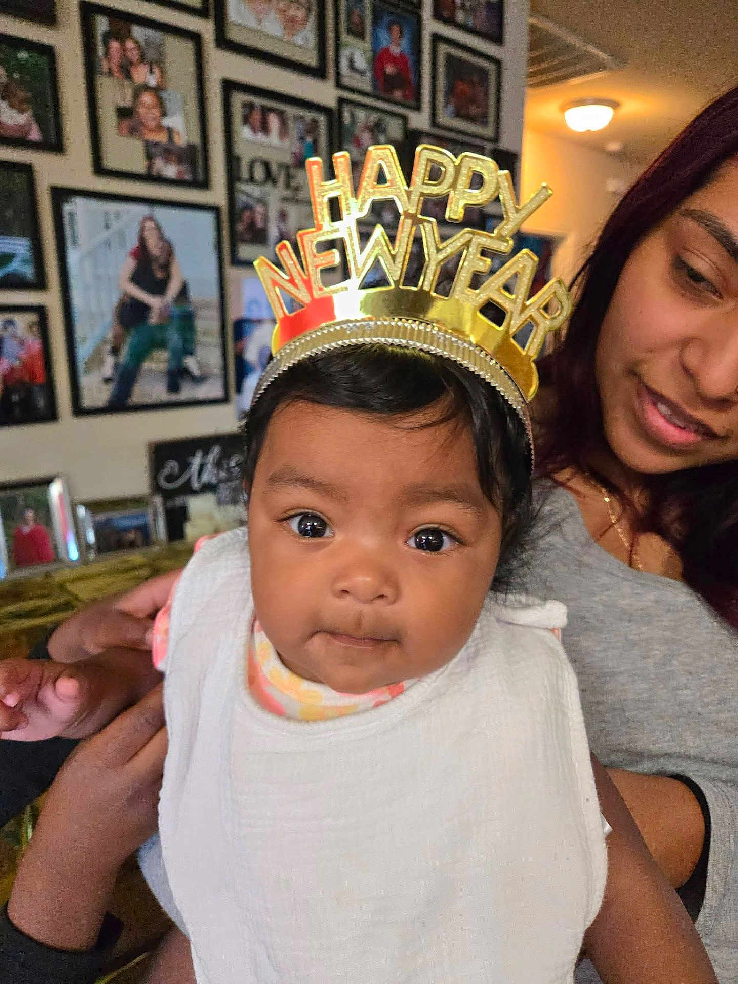 Mia Michelle is registered to the contest to win money with this photo: baby, child, woman, face, portrait, indoor, family, photo_wall, crown, new_year, celebration, smile, clothing, person, holding, curious, headwear, closeup, happy, toddler