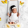 baby, infant, sleeping, swing, white_dress, floral_headband, flowers, butterflies, clouds, soft_texture, cute, portrait, newborn, decorative, studio_photo, peaceful, hands, feet, indoor, adorable