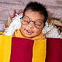 baby, glasses, blanket, smile, tongue, face, child, cute, portrait, wrapped, cozy, warm, soft, happy, infant, young_child, head, lying_down, colorful, texture