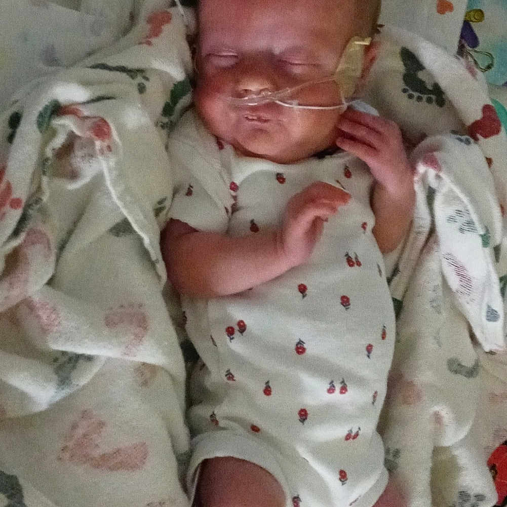 Vivian is registered to the contest to win money with this photo: baby, baby_products, baby_safety, baby_toddler_clothing, bedtime, cheek, child, comfort, head, infant_bed, linens, mammal, mouth, pink, product, skin, sleeve, smile, textile, toddler