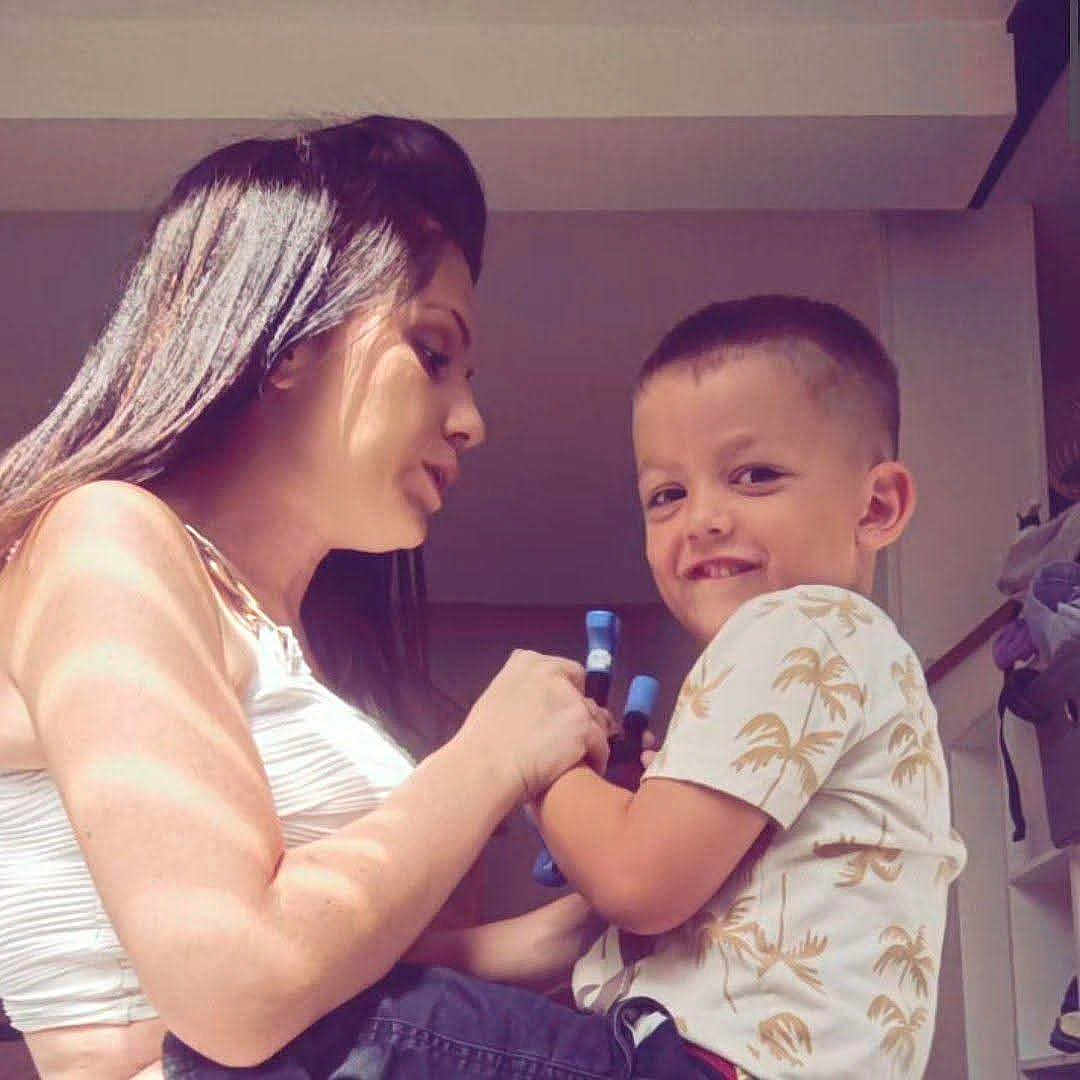 Logan participe au concours pour gagner de l'argent avec cette photo : woman, child, indoor, smiling, holding, markers, sunlight, shadow, short_hair, white_shirt, patterned_shirt, interaction, happy, family, casual_clothing, portrait, closeup, home, person, toddler