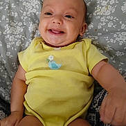 Evalynn joined the competition — help win amazing prizes! baby, child, clothing, comfort, cute, expression, face, floral_blanket, hand, happy, indoors, infant, legs, lying_down, person, portrait, skin, smile, toddler, yellow_onesie