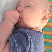 Liam joined the competition — help win amazing prizes! baby, sleeping, thumb_sucking, onesie, blue_clothing, infant, face, ear, hand, arm, crib, wooden_bars, soft_surface, closeup, peaceful, cute, child, indoors, portrait, resting