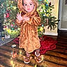 toddler, child, christmas_tree, holiday, festive_lights, wooden_floor, reindeer_costume, slippers, indoor, home, decorations, cute, seasonal, warm_clothing, person, standing, christmas_decor, holiday_spirit, festivity, curious