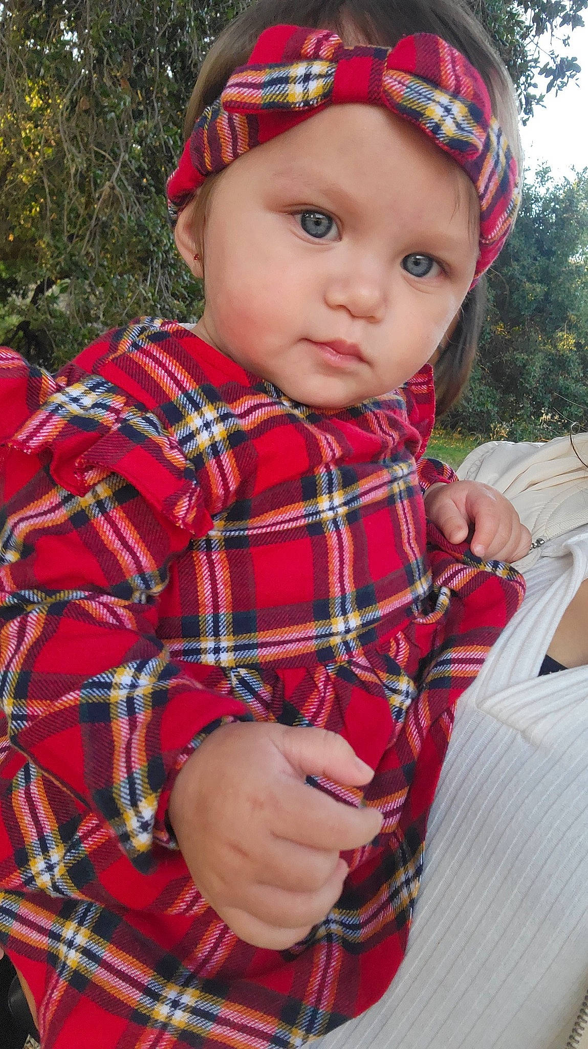 Evalina joined the competition — help win amazing prizes! baby_toddler_clothing, cap, child, collar, design, eye, grass, head, headwear, lip, pattern, person, plaid, plant, red, sitting, sleeve, tartan, textile, toddler