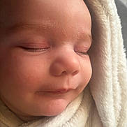 Arthur participe au concours pour gagner de l'argent avec cette photo : baby, sleeping, close_up, blanket, soft, face, infant, peaceful, wrapped, cozy, child, newborn, skin, nose, eyelids, mouth, head, warm, comfort, portrait