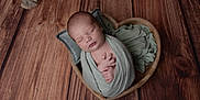 Arthur a rejoint le concours — aidez-le/la à gagner de superbes lots ! newborn, baby, sleeping, wrapped, blanket, heart_shaped_bowl, wooden_floor, cozy, peaceful, infant, soft, pillow, dried_leaves, natural, portrait, indoors, calm, hands, tiny, cute