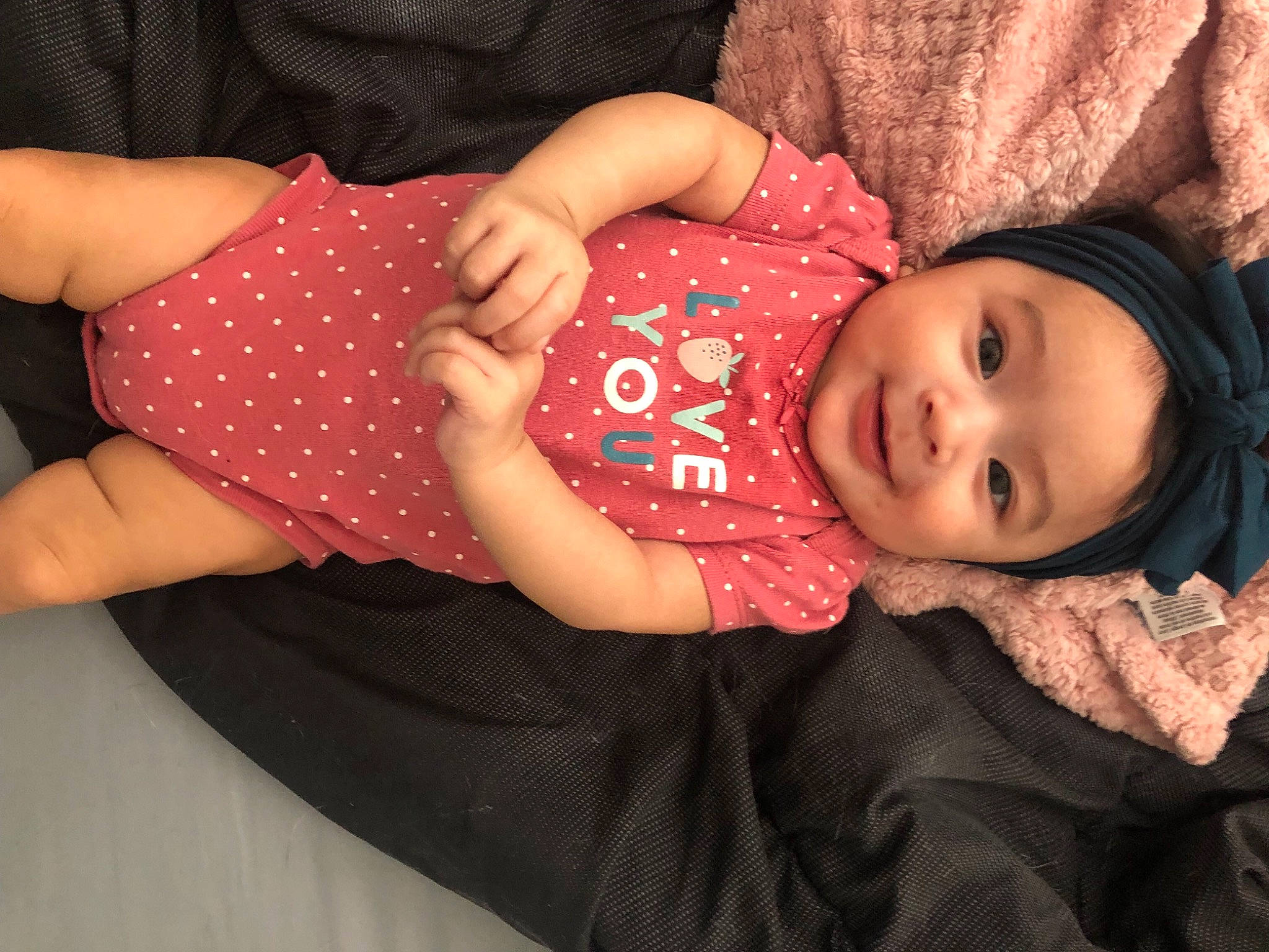 Isabella is registered to the contest to win money with this photo: baby, baby_toddler_clothing, cheek, child, comfort, elbow, gesture, grass, happy, human_body, human_leg, joy, nail, pattern, person, pink, sleeve, smile, thigh, toddler