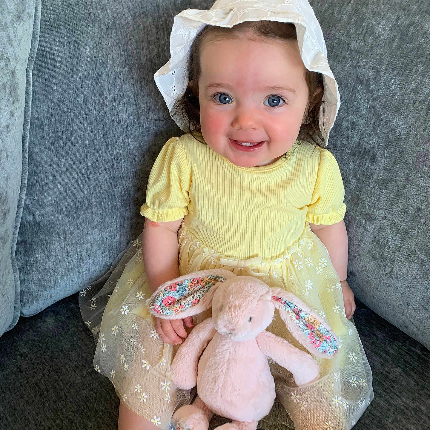 Lucía joined the competition — help win amazing prizes! baby, bonnet, cap, clothing, costume, couch, cushion, dress, face, furniture, hat, head, homedecor, pants, person, photography, portrait, sitting, sunhat, toy