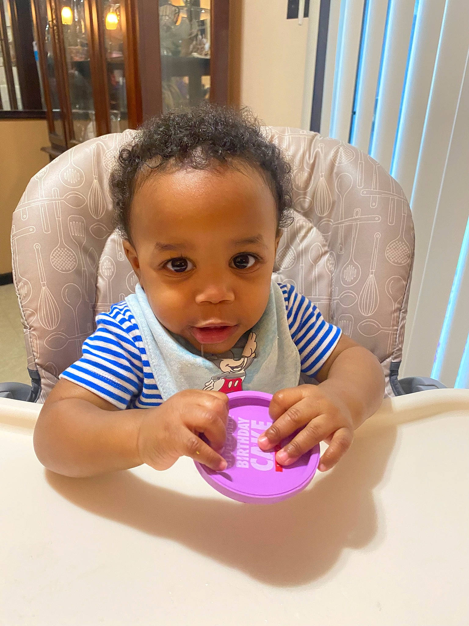 Brian is registered to the contest to win money with this photo: baby, baby_toddler_clothing, bathing, chair, cheek, child, drinkware, eyelash, finger, flooring, fun, hand, happy, nail, nose, person, picture_frame, skin, table, thumb