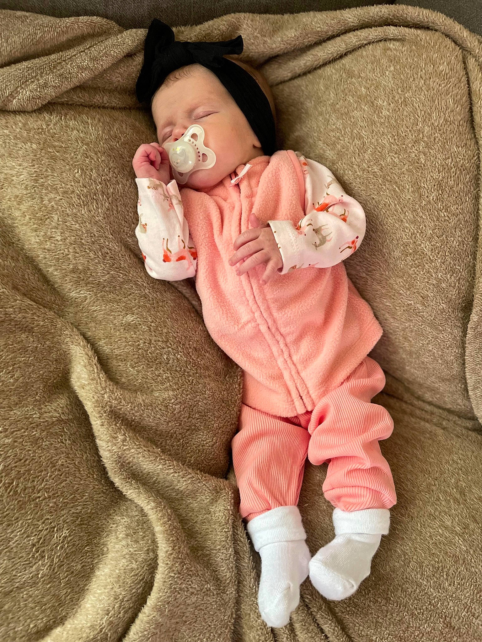 Stella is registered to the contest to win money with this photo: baby, baby_products, baby_sleeping, baby_toddler_clothing, cheek, child, comfort, eye, face, fur, gesture, linens, peach, person, pink, sitting, skin, sleeve, sock, textile