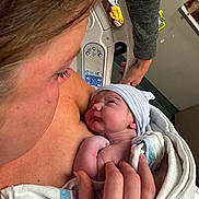 Brody is registered to the contest to win money with this photo: newborn, baby, mother, hospital, blanket, hat, skin, hand, person, bed, love, care, family, intimate, hospital_room, human, closeup, newborn_baby, parent, caring