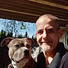 Virgel is registered to the contest to win money with this photo: man, dog, outdoor, sunlight, smile, pet, collar, leash, tree, house, porch, face, person, canine, closeup, daylight, casual, friendship, portrait, animal