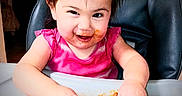 Valentina is registered to the contest to win money with this photo: toddler, child, messy, food, beans, highchair, pigtails, pink_shirt, happy, smiling, face, hands, indoor, meal_time, cute, playful, expression, young_child, portrait, table