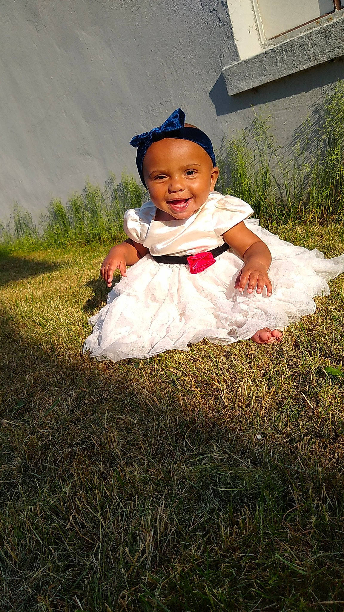 Ella is registered to the contest to win money with this photo: baby, baby_toddler_clothing, child, dress, face, flash_photography, fun, grass, grass_family, grassland, happy, joy, lawn, meadow, people_in_nature, person, plant, prairie, sitting, smile