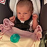 baby, infant, car_seat, blanket, pacifier, pink, clothing, face, person, child, newborn, resting, indoors, seatbelt, cute, small_hands, portrait, expression, sleepy, cozy