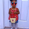 toddler, child, sunglasses, strawberry, red_top, denim_skirt, patterned_tights, sneakers, straw_purse, standing, indoor, white_door, flooring, fashion, accessories, cute, portrait, person, young_child, hair_updo