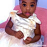 Khloe is registered to the contest to win money with this photo: toddler, child, dress, cream_dress, flower_appliques, pink_chair, hairstyle, puffed_hair, indoor, portrait, curious_expression, big_eyes, sitting, cute, fashion, young_child, innocent, fancy_clothing, person, photograph