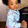 child, toddler, person, denim_jacket, strawberry_embroidery, red_checkered_skirt, hair_clips, curly_hair, indoor, door, adult_hand, holding, portrait, face, expression, clothing, cute, young_child, fashion, standing