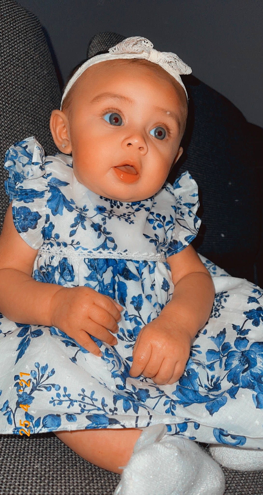 Emmaleigh is registered to the contest to win money with this photo: azure, baby, baby_products, baby_toddler_clothing, blue, cap, cheek, child, collar, comfort, day_dress, electric_blue, face, iris, pattern, person, sitting, skin, sleeve, surprise