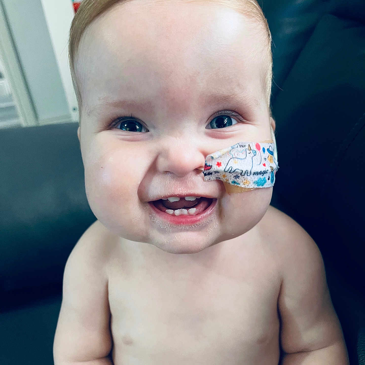 Tomi Magee is registered to the contest to win money with this photo: baby, babylaughing, bandage, blonde, bodypart, cutlery, face, firstaid, hair, happy, head, laughing, mouth, person, photography, portrait, sitting, smile, spoon, teeth