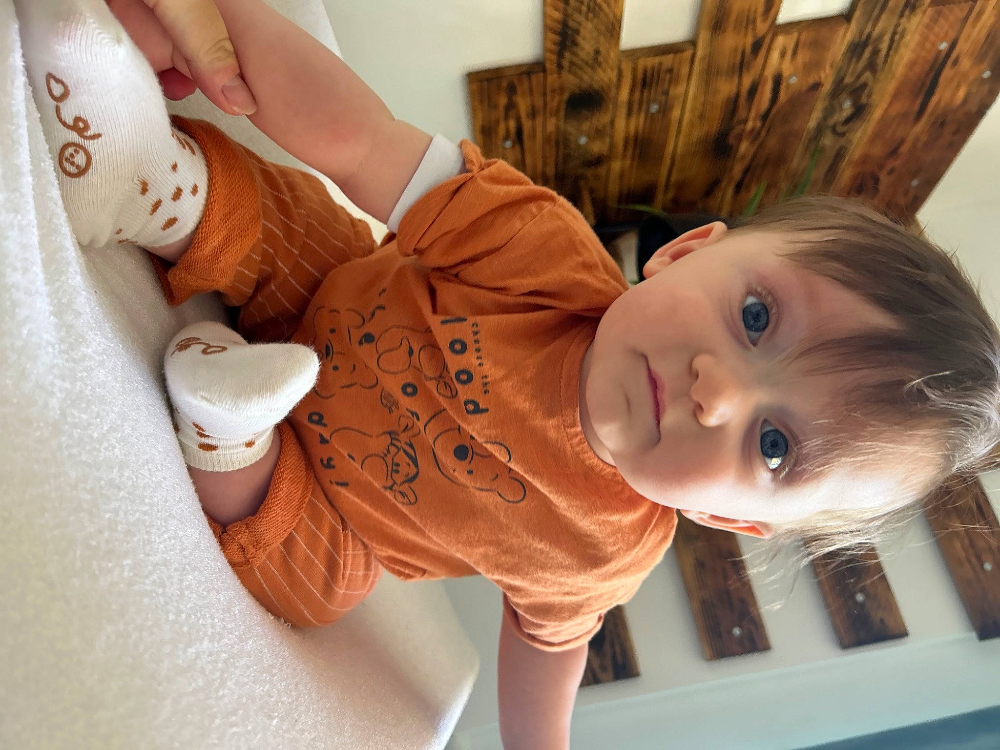 Milo a rejoint le concours — aidez-le/la à gagner de superbes lots ! baby, baby_products, baby_toddler_clothing, cheek, child, cup, drinkware, elbow, flooring, happy, hardwood, person, room, serveware, sitting, skin, sleeve, smile, teacup, toddler