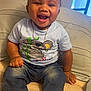 Jhamir is registered to the contest to win money with this photo: toddler, child, smiling, happy, sitting, jeans, tshirt, sneakers, indoors, couch, furniture, face, person, cute, clothing, young_child, portrait, expression, gold_chain, window