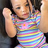 Damiyah joined the competition — help win amazing prizes! beads, braids, casual_wear, child, colorful_clothing, cute, fashion, flower_patch, fun, happy, indoors, joyful, person, portrait, raised_fists, sitting, smiling, striped_outfit, toddler, young_child