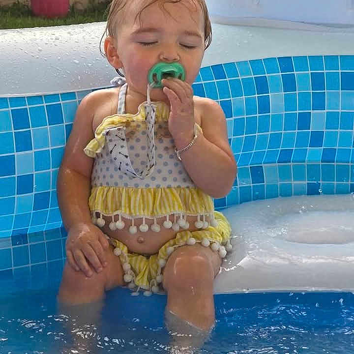 Olivia joined the competition — help win amazing prizes! baby, blue, child, cute, face, fun, innertube, outdoor, pacifier, playtime, pool, relaxing, sitting, skin, summer, sunlight, swimsuit, toddler, water, yellow