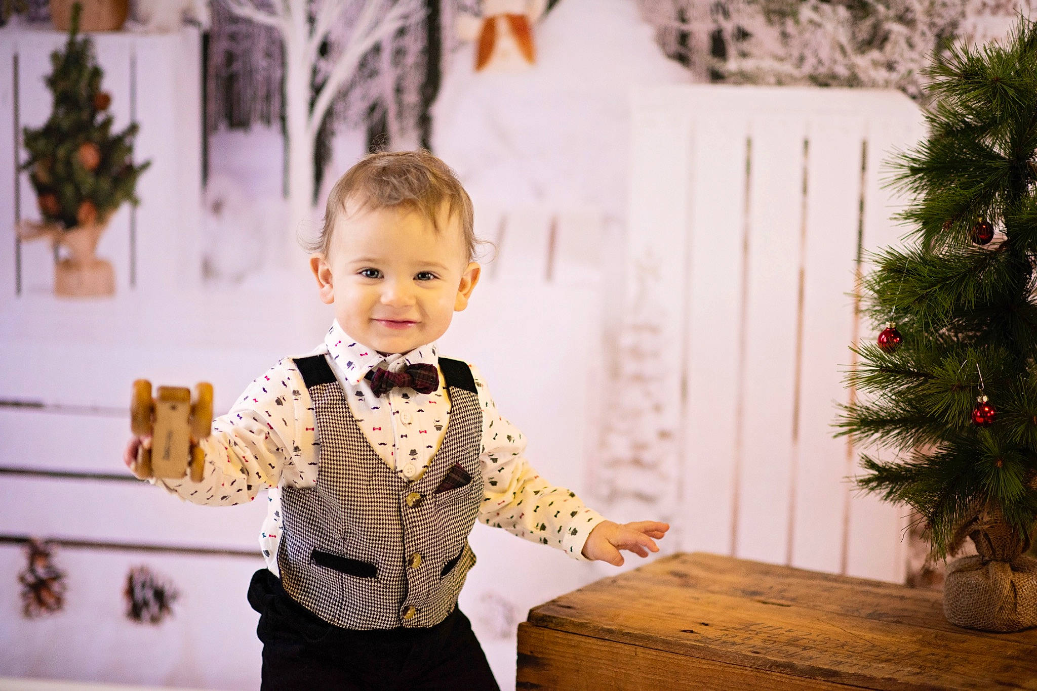 Atticus is registered to the contest to win money with this photo: baby, baby_toddler_clothing, bow_tie, child, christmas, christmas_decoration, christmas_ornament, christmas_tree, collar, conifer, ear, evergreen, fir, flowerpot, holiday, interior_design, joy, ornament, person, pine_family